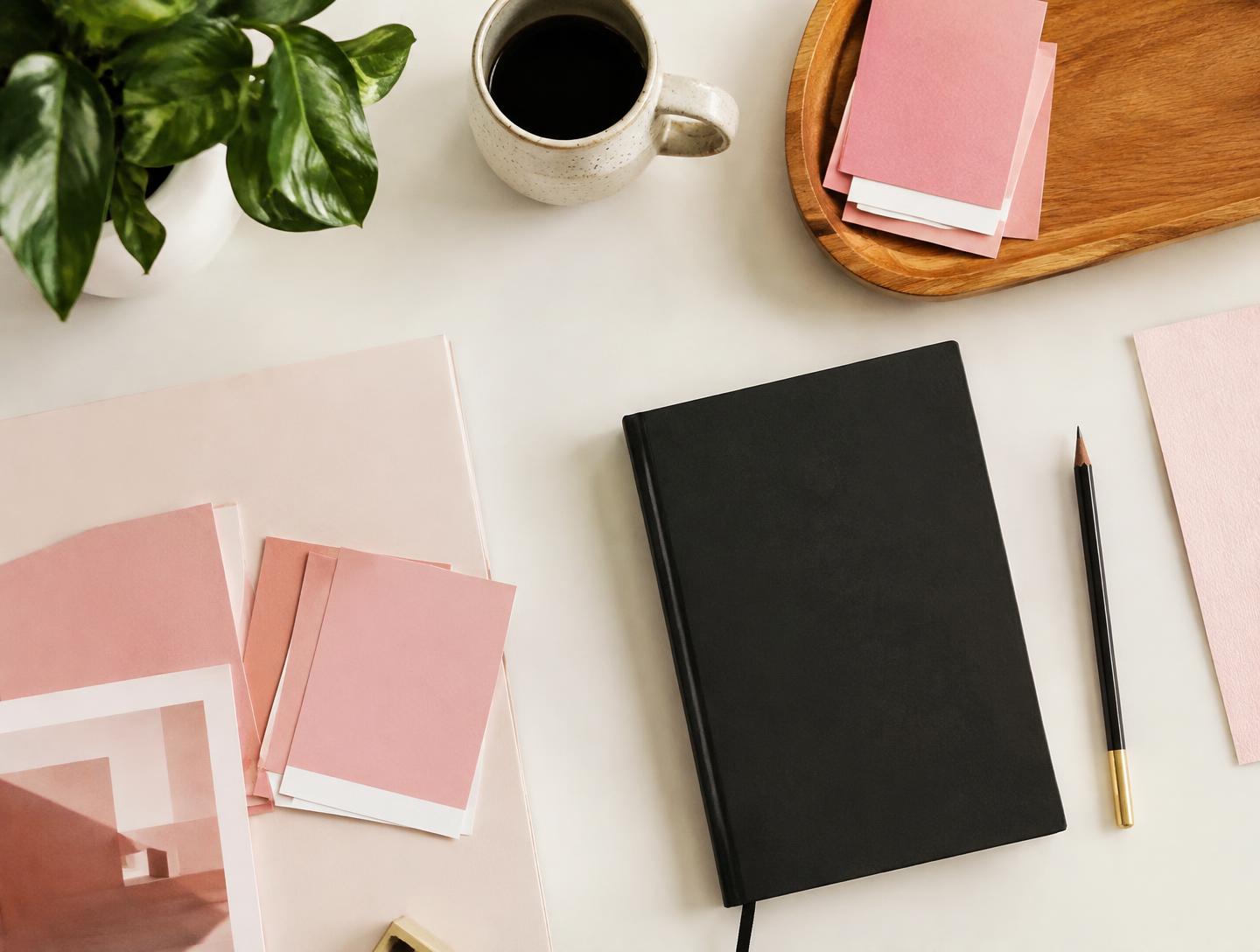 Brand collateral, colour swatches and a notebook laid out on a studio desk